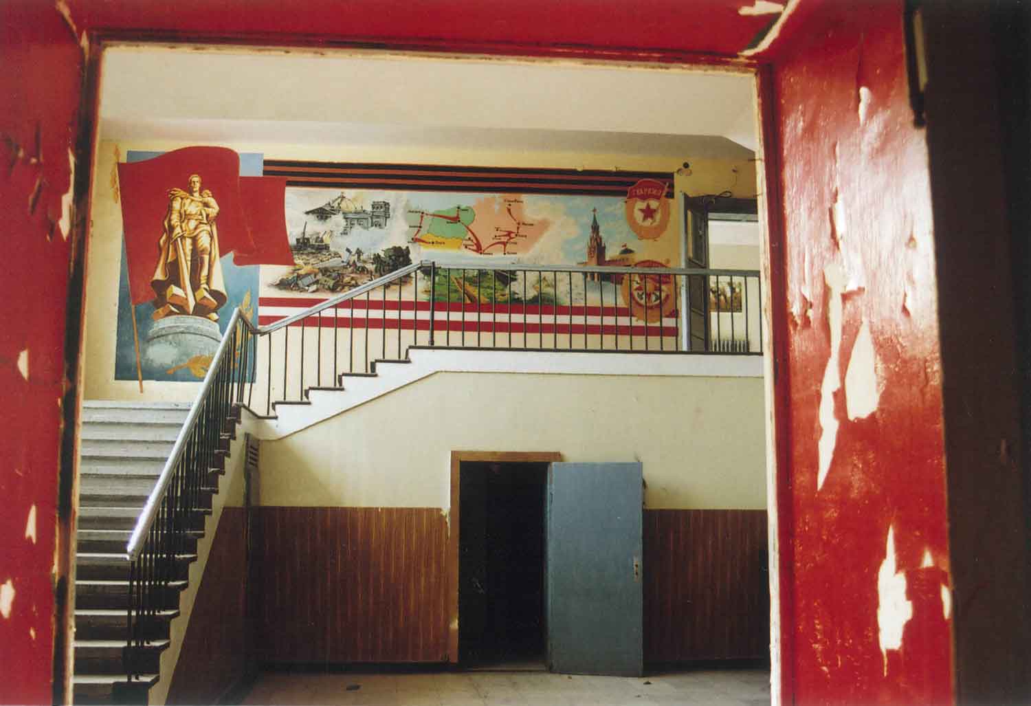 Foto, farbig, innen: Treppenaufgang mit Wandmalerei.